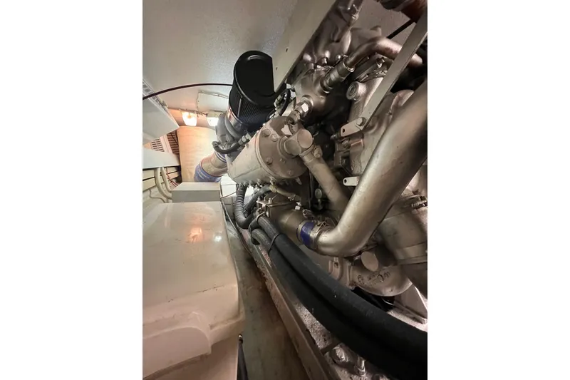 Slide: The Image of Engine room of a 1991 Viking Convertible boat, showcasing intricate machinery and piping. - 75