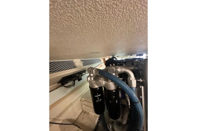 Slide: The Image of Engine room of a 1991 Viking Convertible boat with visible filters and hoses. - 78