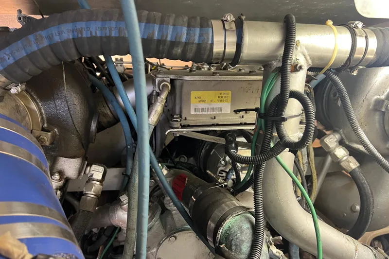 Slide: The Image of Engine compartment of a 1991 Viking Convertible boat, showcasing hoses and mechanical components. - 83