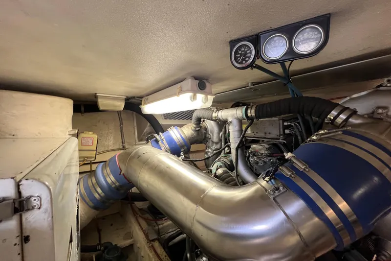 Slide: The Image of Engine room of a 1991 Viking Convertible boat with visible gauges and piping. - 90
