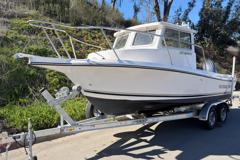 Slide: The Image of 2026 Defiance Admiral 220 EX boat on trailer, parked outdoors. - 2