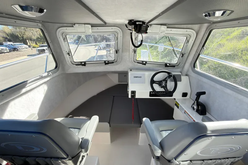Slide: The Image of Interior of 2026 Defiance Admiral 220 EX boat with steering wheel and seating. - 21