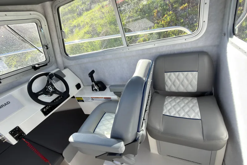 Slide: The Image of Interior of 2026 Defiance Admiral 220 EX boat with steering wheel and cushioned seats. - 23