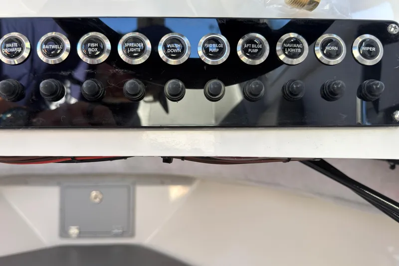 Slide: The Image of Control panel of 2026 Defiance Admiral 220 EX boat with labeled switches. - 28