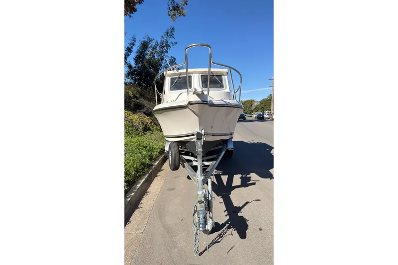 Slide: The Image of 2026 Defiance Admiral 220 EX boat on trailer, parked on a sunny street. - 3