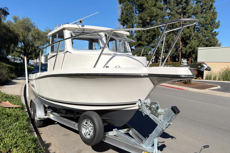 Slide: The Image of 2026 Defiance Admiral 220 EX boat on trailer, parked on a sunny street. - 35