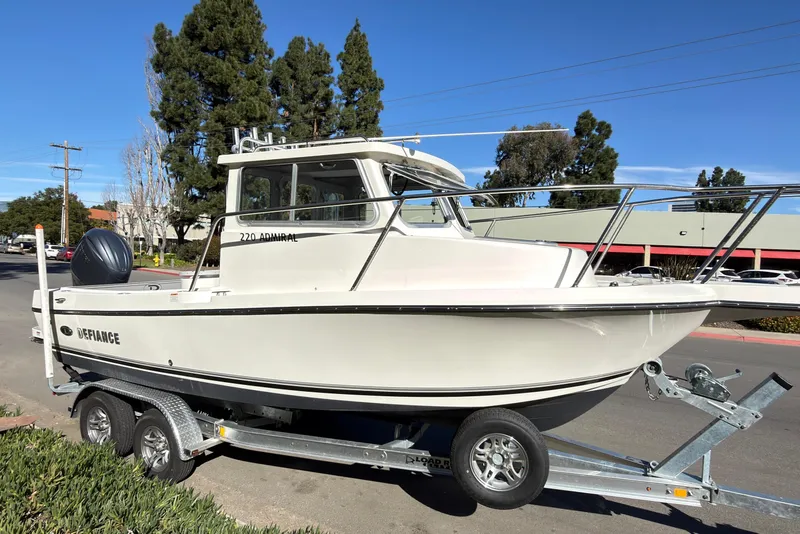 Slide: The Image of 2026 Defiance Admiral 220 EX boat on trailer, parked on street, clear sky background. - 36