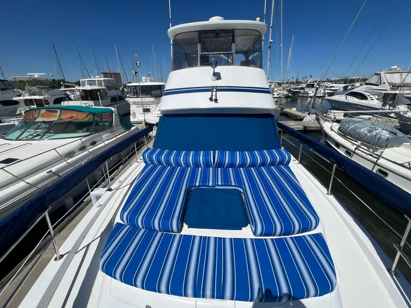 Slide: The Image of 1986 Gulfstar 44 Aft Cabin yacht with blue-striped deck cushions in a marina. - 14