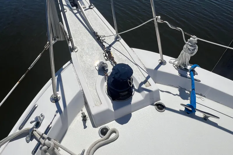 Slide: The Image of 1986 Gulfstar 44 Aft Cabin deck with winch and ropes, docked on calm water. - 18