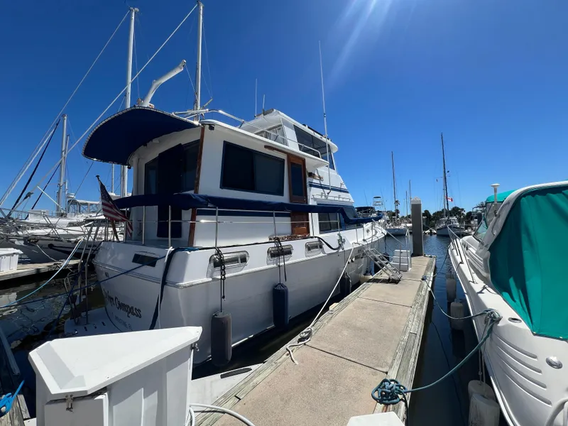 Slide: The Image of 1986 Gulfstar 44 Aft Cabin yacht docked at marina under clear blue sky. - 2