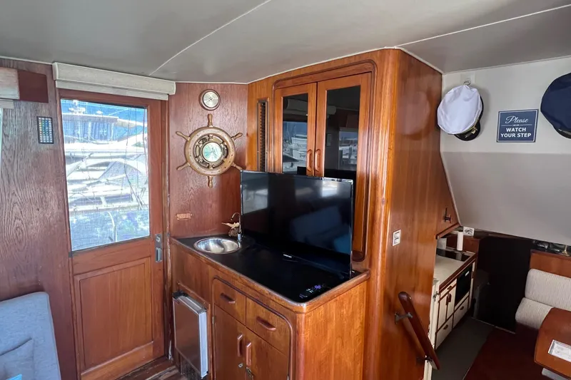 Slide: The Image of Interior of 1986 Gulfstar 44 Aft Cabin with wood cabinetry and mounted TV. - 25