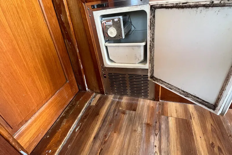 Slide: The Image of 1986 Gulfstar 44 Aft Cabin interior with open mini fridge and wooden flooring. - 26