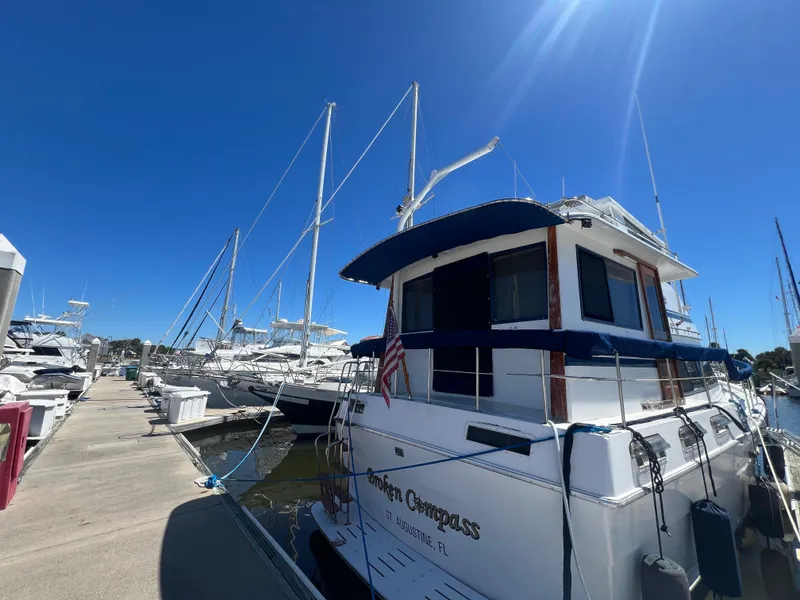 Slide: The Image of 1986 Gulfstar 44 Aft Cabin yacht docked at marina under clear blue sky. - 3