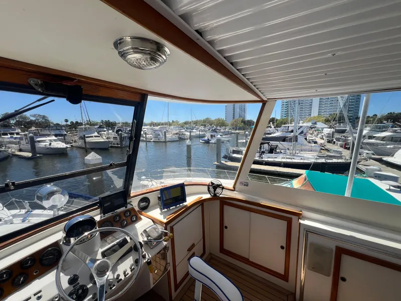 Slide: The Image of Interior view of 1986 Gulfstar 44 Aft Cabin yacht at marina, showcasing helm and controls. - 31