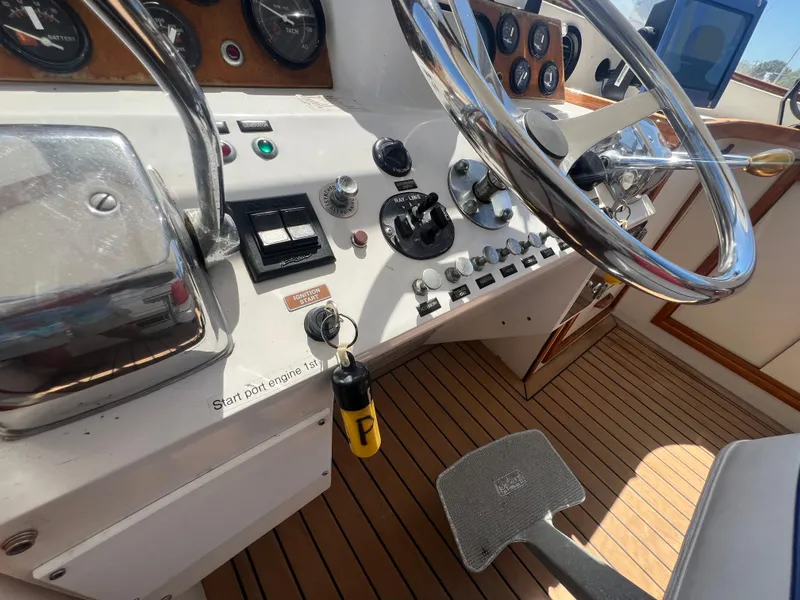 Slide: The Image of 1986 Gulfstar 44 Aft Cabin yacht helm with steering wheel and control panel. - 36