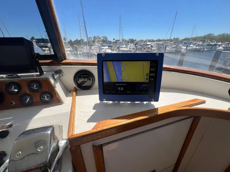 Slide: The Image of 1986 Gulfstar 44 Aft Cabin helm with navigation display, marina view in background. - 38