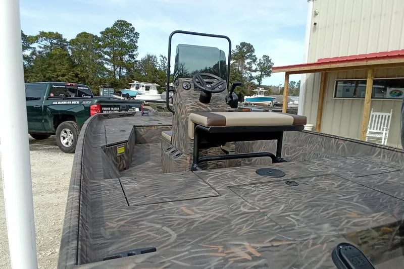 Slide: The Image of 2026 Alweld 2070 Vortex boat with camo design, parked near a building and truck. - 12