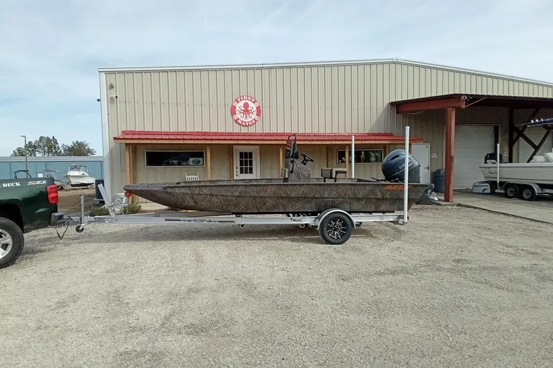 Slide: The Image of 2026 Alweld 2070 Vortex boat on trailer outside a metal building. - 2