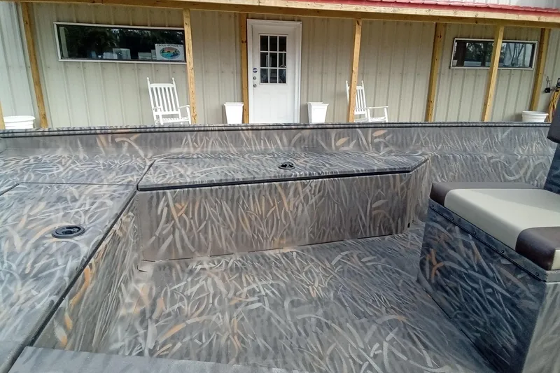 Slide: The Image of 2026 Alweld 2070 Vortex boat with camo interior, parked near a porch with rocking chairs. - 7