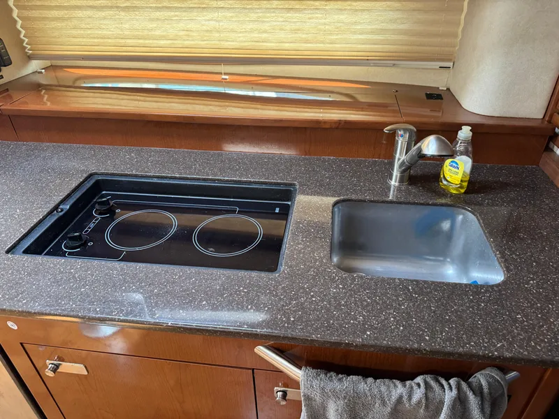 Slide: The Image of Luxurious 2012 Sea Ray 370 Sundancer kitchen with stove, sink, and countertop. - 11