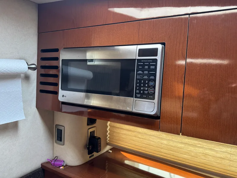 Slide: The Image of Microwave in 2012 Sea Ray 370 Sundancer yacht kitchen with wooden cabinetry. - 13