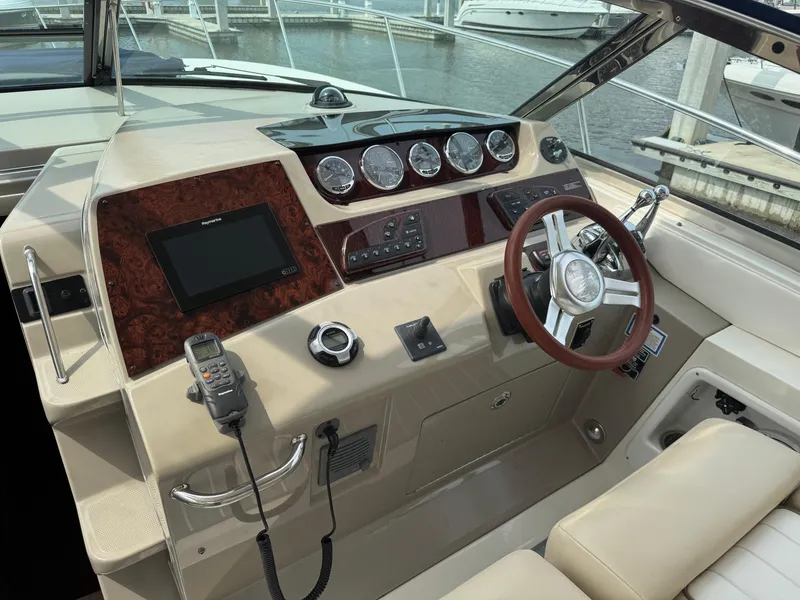 Slide: The Image of Helm of 2012 Sea Ray 370 Sundancer with steering wheel, gauges, and navigation equipment. - 16