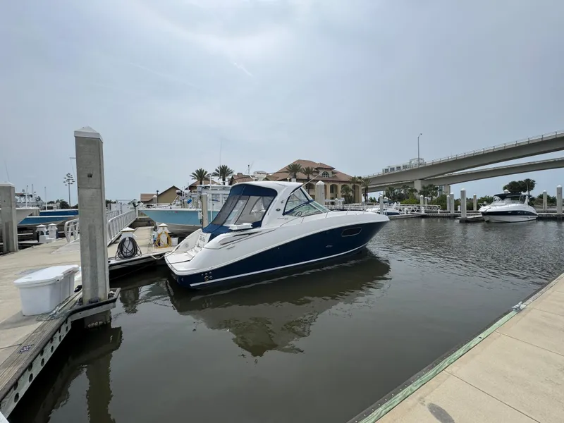Slide: The Image of 2012 Sea Ray 370 Sundancer docked at a marina under a cloudy sky. - 2