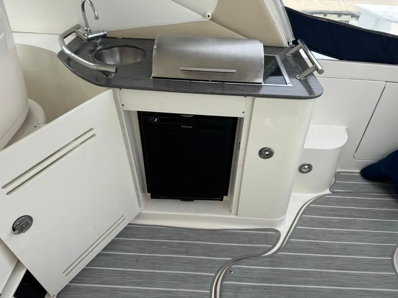 Slide: The Image of Outdoor kitchenette on 2012 Sea Ray 370 Sundancer with sink, grill, and fridge. - 21