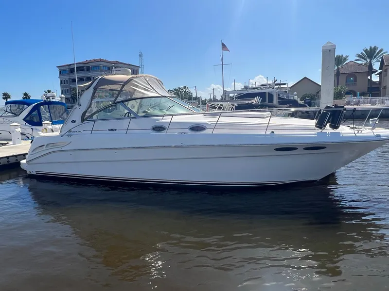 The Image of 2002 Sea Ray 340 Sundancer yacht docked at a marina under clear blue skies. - 0