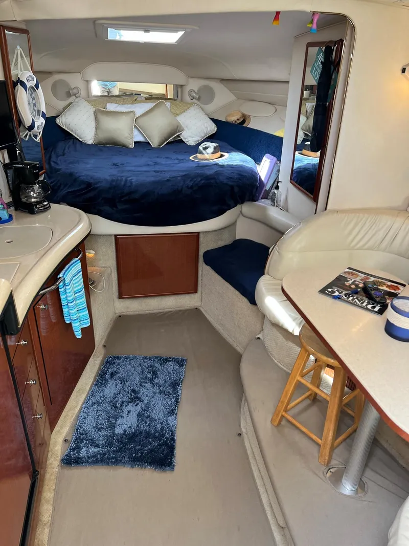 Slide: The Image of Interior of 2002 Sea Ray 340 Sundancer yacht with cozy seating and elegant bedding. - 11