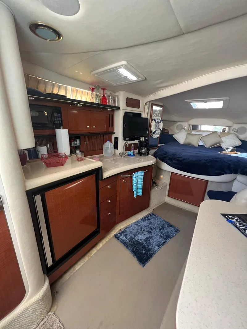 Slide: The Image of Interior of 2002 Sea Ray 340 Sundancer yacht with kitchenette and cozy sleeping area. - 13