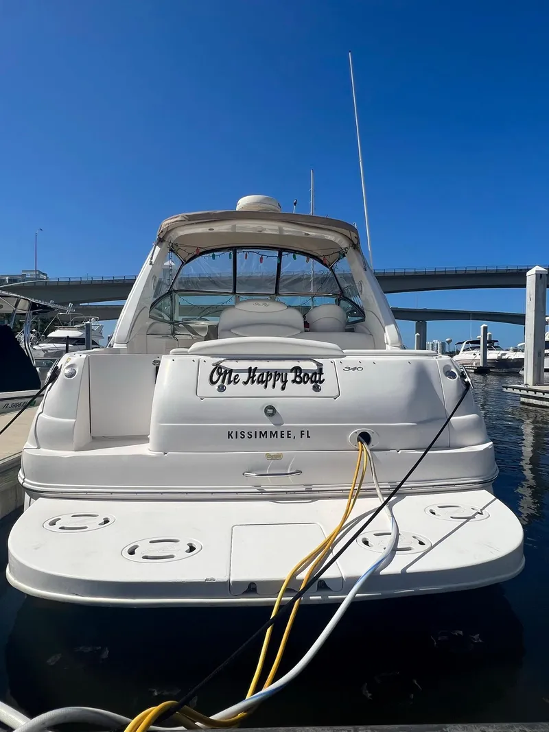 Slide: The Image of 2002 Sea Ray 340 Sundancer docked, rear view, with "One Happy Boat" nameplate, Kissimmee, FL. - 4