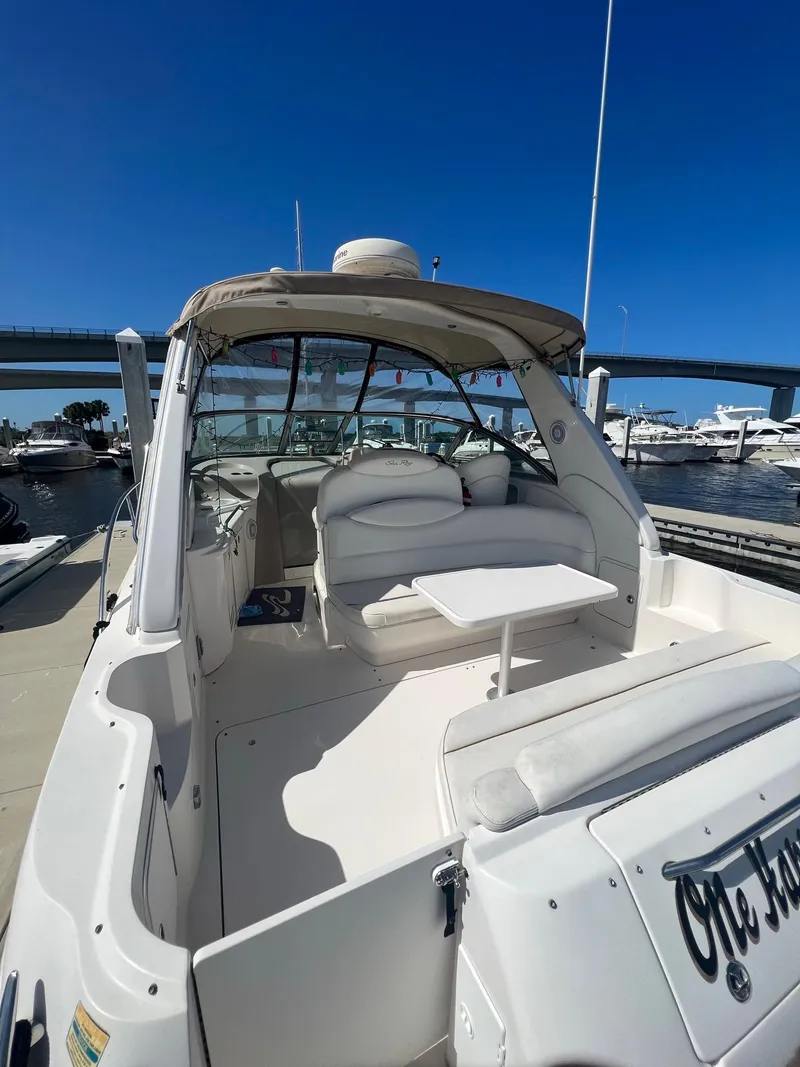 Slide: The Image of 2002 Sea Ray 340 Sundancer boat with spacious seating and table, docked at marina. - 5