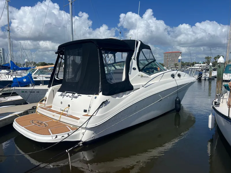 The Image of 2003 Sea Ray 320 Sundancer boat docked in a marina under a blue sky. - 0
