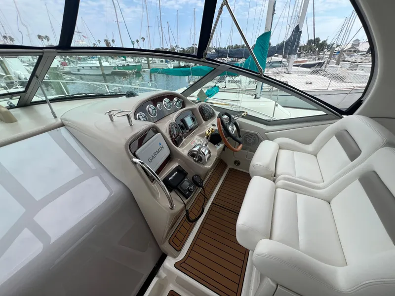 Slide: The Image of Interior cockpit of 2003 Sea Ray 320 Sundancer with modern controls and white seating. - 14