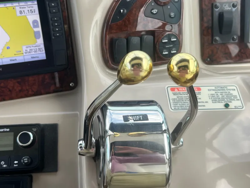 Slide: The Image of Control panel of a 2003 Sea Ray 320 Sundancer boat with navigation and throttle levers. - 16