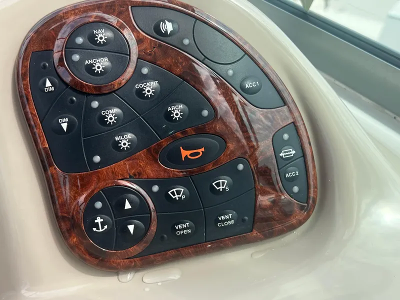 Slide: The Image of Control panel of a 2003 Sea Ray 320 Sundancer boat with various function buttons. - 18