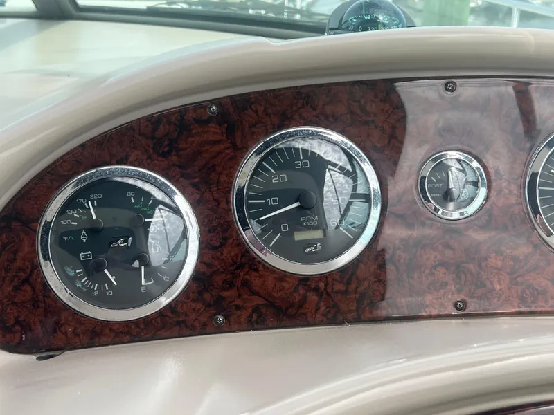Slide: The Image of Dashboard of 2003 Sea Ray 320 Sundancer with wood paneling and gauges. - 19