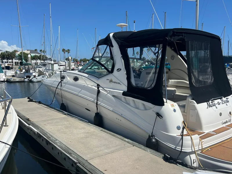 Slide: The Image of 2003 Sea Ray 320 Sundancer docked at marina under clear blue sky. - 2