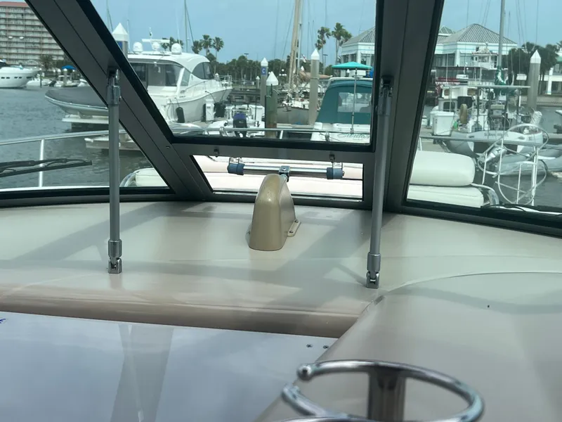 Slide: The Image of 2003 Sea Ray 320 Sundancer cockpit view in marina, showcasing helm and surrounding boats. - 26