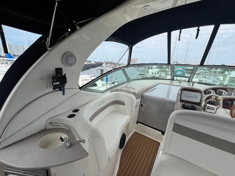 Slide: The Image of 2003 Sea Ray 320 Sundancer cockpit with modern controls and seating, docked at marina. - 28