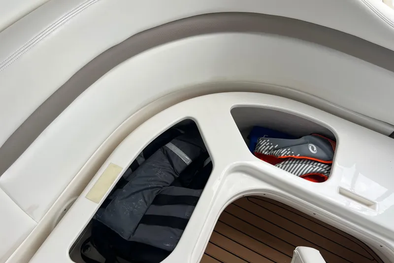 Slide: The Image of 2003 Sea Ray 320 Sundancer interior storage compartments with life jacket and shoes. - 36