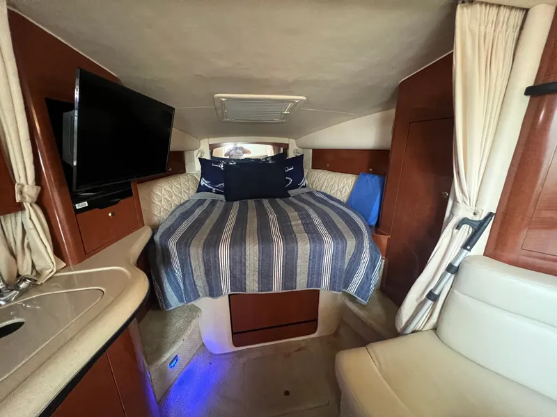 Slide: The Image of Interior cabin of 2003 Sea Ray 320 Sundancer with bed, TV, and seating area. - 48