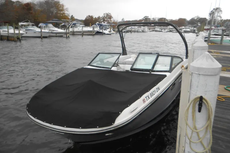 Slide: The Image of 2019 Monterey 298SS Super Sport boat docked with cover, marina background. - 11