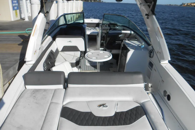 Slide: The Image of 2019 Monterey 298SS Super Sport boat interior with seating and table, docked by the water. - 3