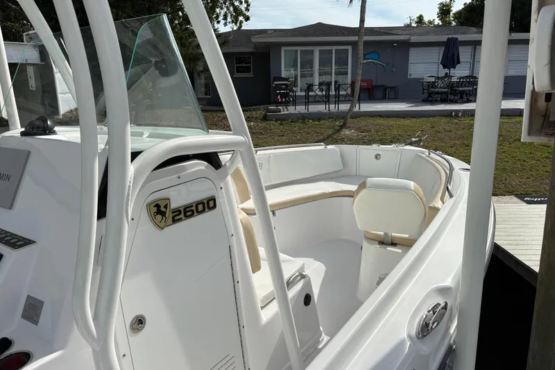 Slide: The Image of 2022 Century 2600 Center Console boat docked near a house, showcasing seating area. - 13