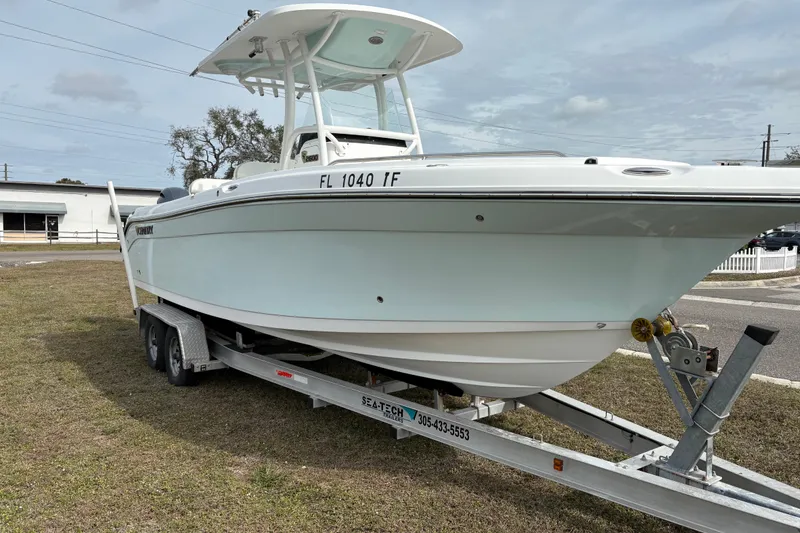 Slide: The Image of 2022 Century 2600 Center Console boat on trailer, parked on grass. - 2
