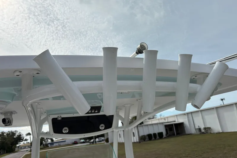 Slide: The Image of Century 2600 Center Console 2022 boat with rod holders and T-top under a cloudy sky. - 23