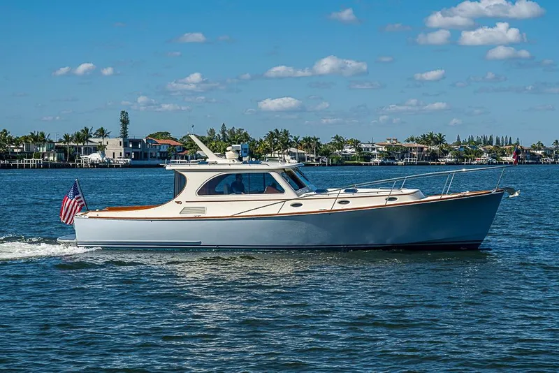 The Image of 2008 Hinckley Talaria 44 MY cruising on a sunny day with coastal homes in the background. - 0