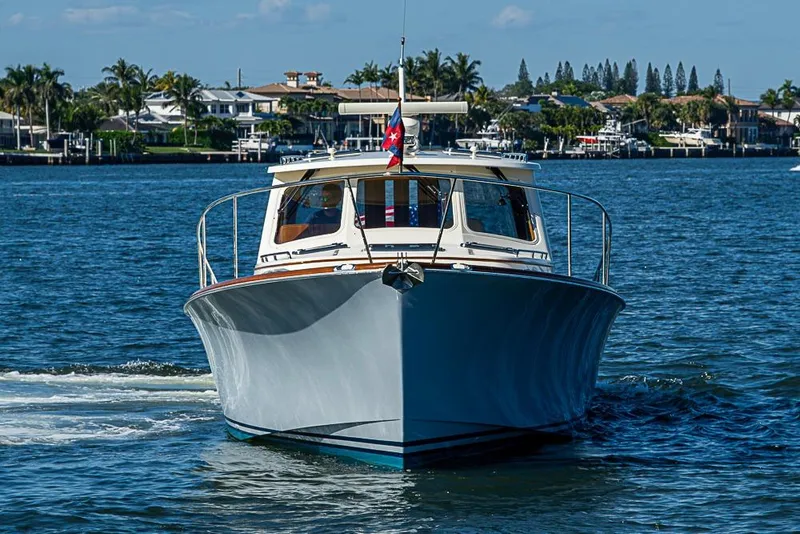 Slide: The Image of 2008 Hinckley Talaria 44 MY yacht cruising on a sunny day near waterfront homes. - 2